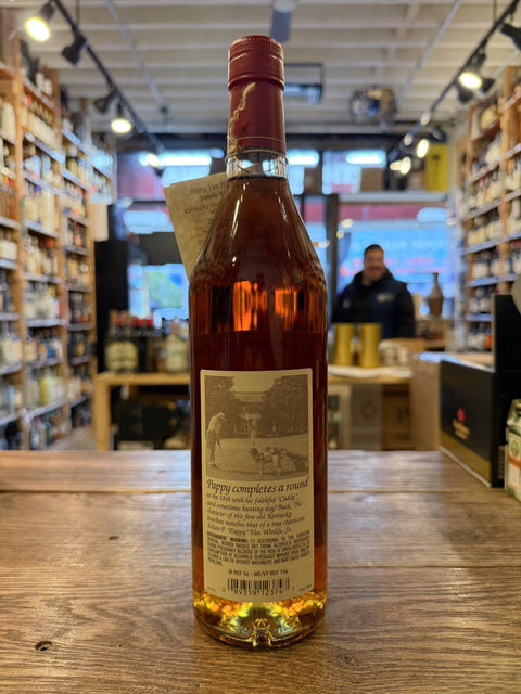 Tall clear bottle with red cap and happy older gentleman smoking a cigar on the label.