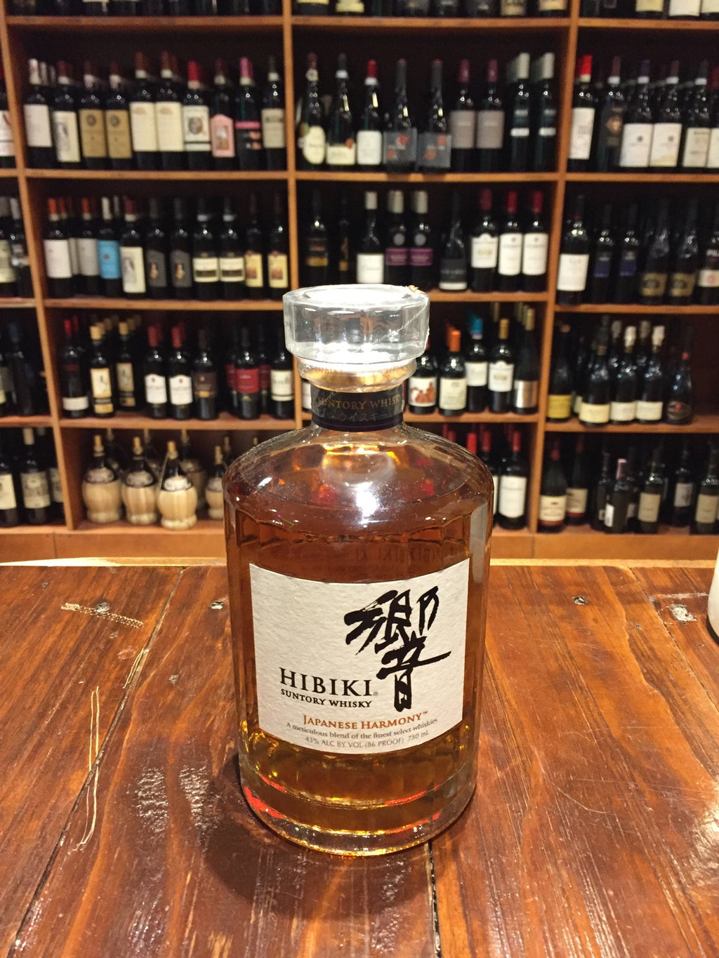 Hibiki Whiskey Harmony 750ml a small circular round clear glass bottle with a white label and glass top