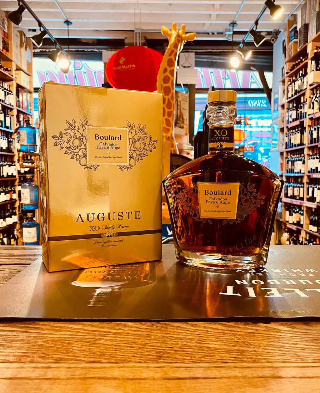 Boulard Calvados Pays d'Auge XO Auguste 750mL a square gold box next to a squared rounded stubby clear bottle with a gold label and gold top