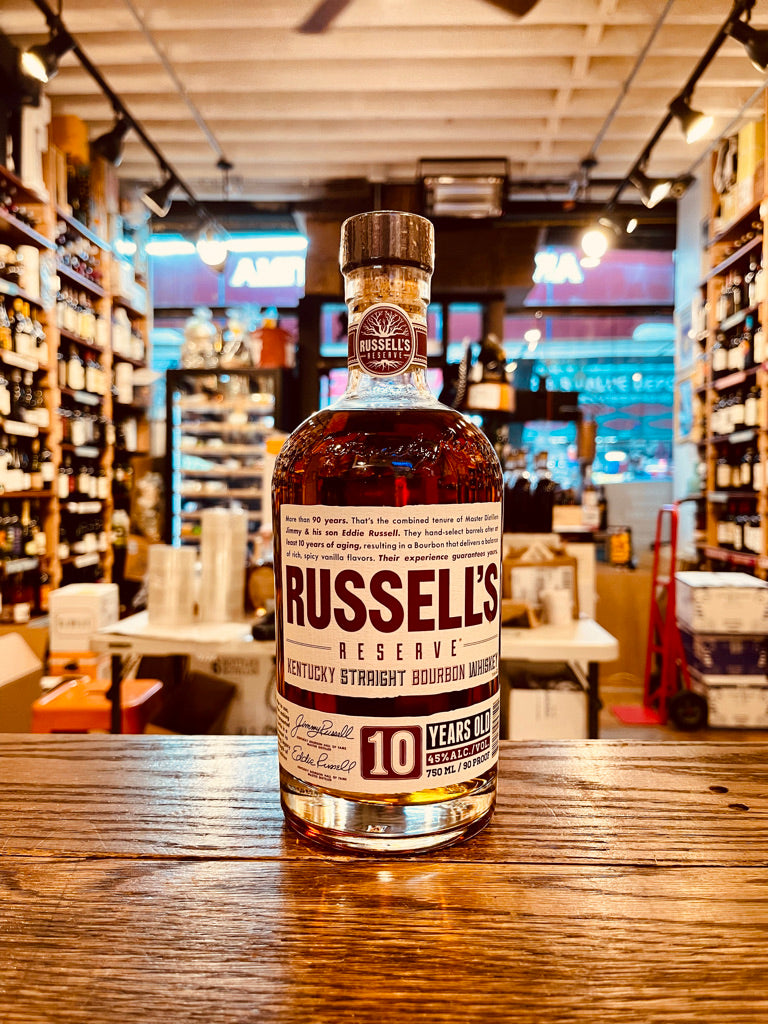 Russells Reserve 10 Year Old 750mL a small squat round shouldered clear glass bottle with a white and maroon label with a wooden top