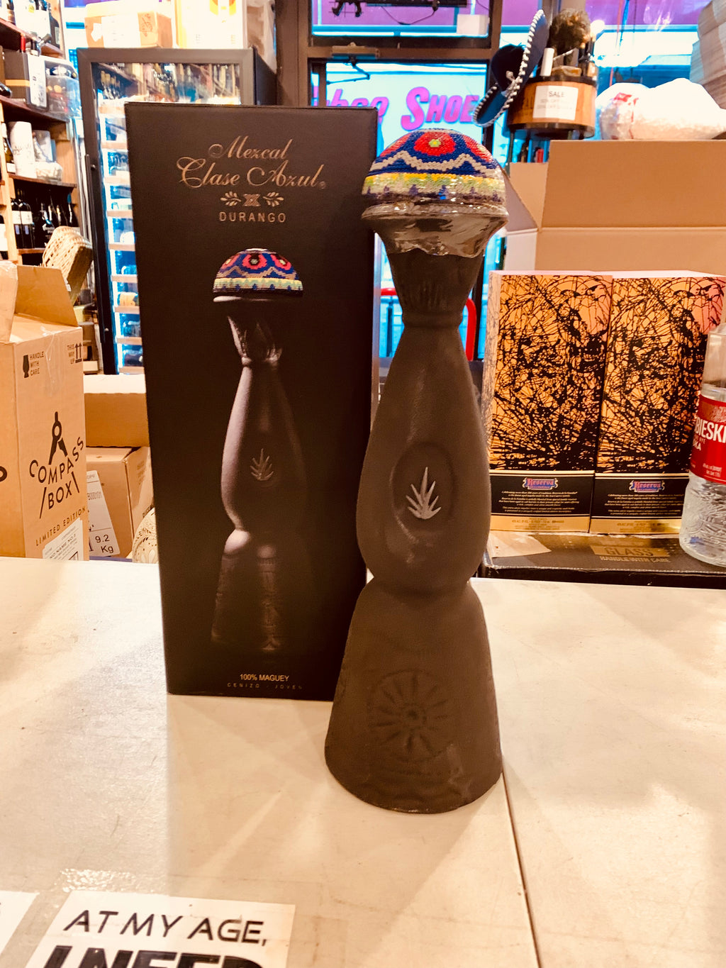 Clase Azul Mezcal Durango 750mL a tall elegantly designed black bottle with a multicolored bell topper next to a tall black box 