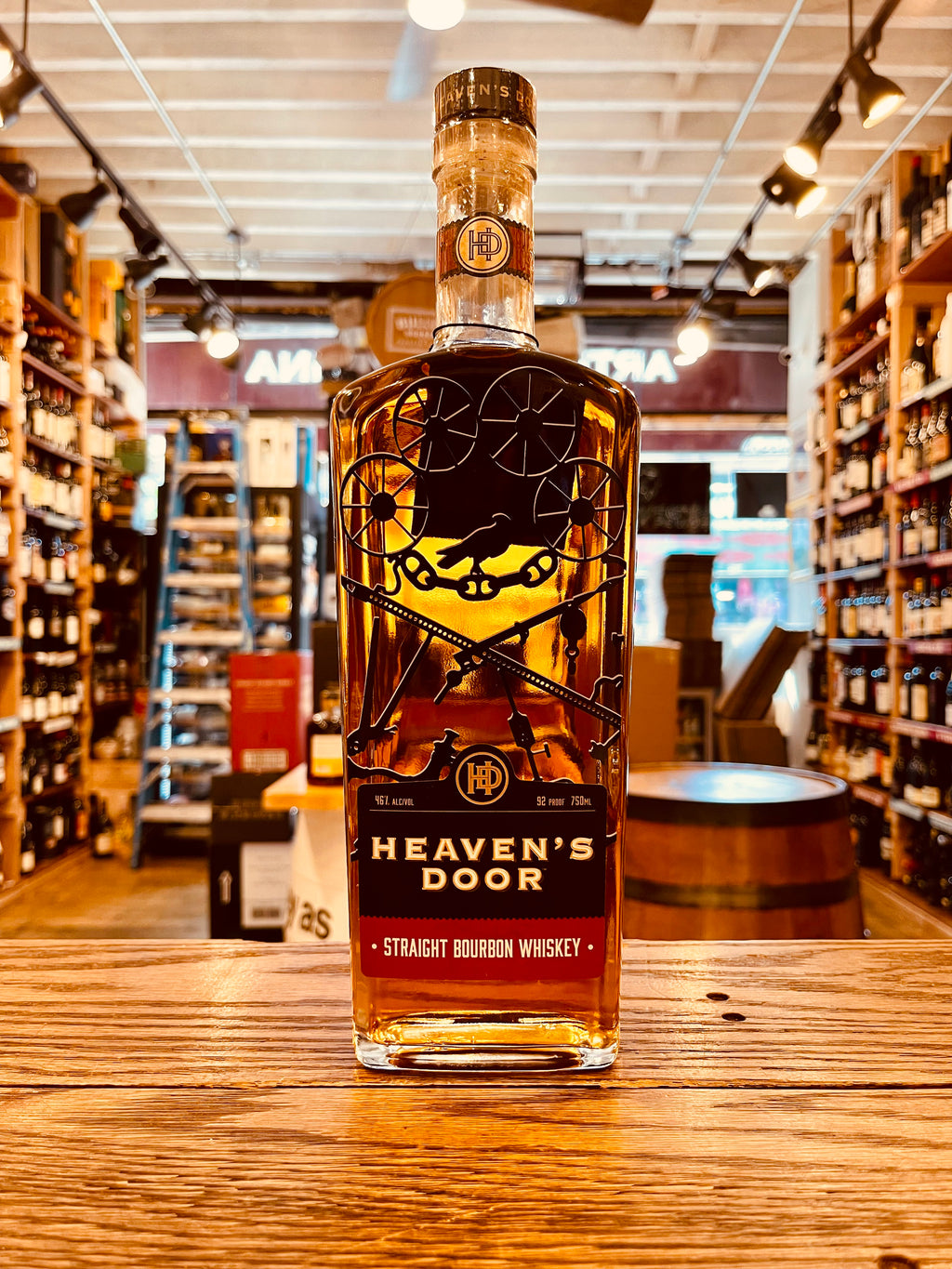 Heaven's Door Tennessee Straight Bourbon Whiskey 750mL a tall flat surfaced squared clear glass bottle with a red label and black graphic on the face of it