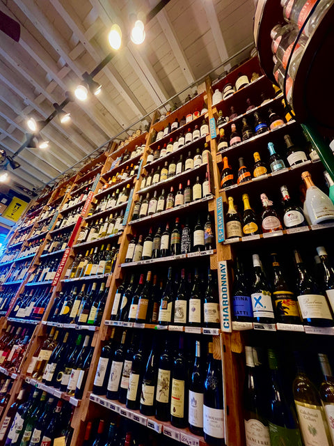 Wall Containing hundreds of wine bottles with various colored labels 