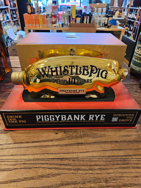 Whistle Pig Piggy Bank Rye 10 Year Limited Edition 750mL a golden piggy bank shaped bottle on top of a flat red and black box.