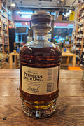 Peerless Bourbon Rum Barrel Finished 750mL a short squat rounded clear glass bottle with a beige and green label with a wooden top