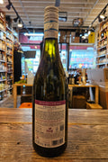 Wine bottle with a label on a wooden surface in a store setting