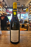 Wine bottle with a yellow label on a wooden surface in a store setting