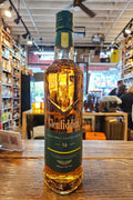 Bottle of Glenfiddich whisky on a wooden surface with a store interior in the background