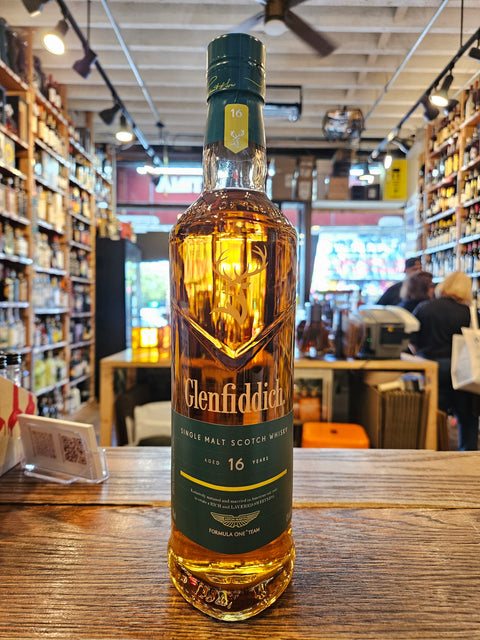 Bottle of Glenfiddich whisky on a wooden surface with a store interior in the background