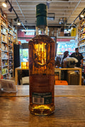 Bottle of whiskey on a wooden surface with a store interior in the background