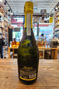 Bottle of Prosecco on a wooden surface with a store interior in the background