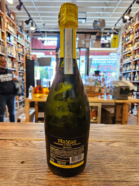 Bottle of Prosecco on a wooden surface with a store interior in the background