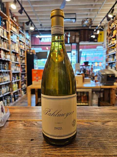 Wine bottle labeled 'Pahlmeyer' on a wooden surface with a store interior in the background