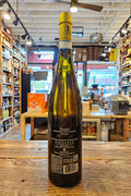 Bottle of wine on a wooden surface with a store interior in the background