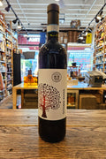 Wine bottle with a label featuring an apple design on a wooden surface.