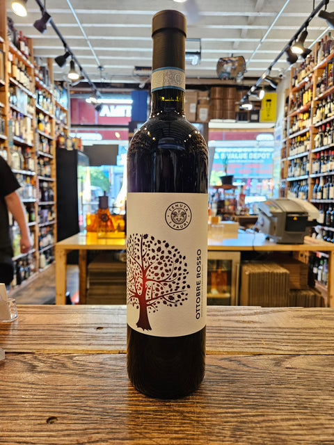 Wine bottle with a label featuring an apple design on a wooden surface.