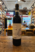 Wine bottle on a wooden surface with a blurred store interior in the background