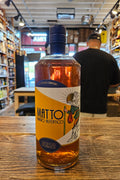 Bottle of Matto on a wooden surface with a blurred indoor background