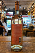 Bottle of wine with a label on a wooden surface in an indoor setting