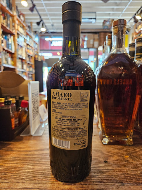 Bottle of Amaro Imperiale on a wooden surface with a blurred store interior in the background