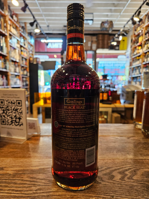 Bottle of Goslings Black Seal Rum on a wooden surface with a store interior in the background.