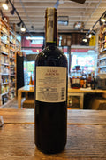 Wine bottle with label on a wooden surface, blurred store interior in the background