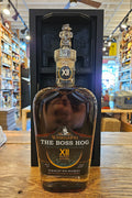 Bottle of 'The Boss Hog XII' whiskey on a wooden surface with a store interior in the background.
