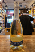 Bottle of Prosecco on a wooden surface with a store interior in the background