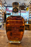 Bottle of Four Roses bourbon on a wooden surface with a blurred store background