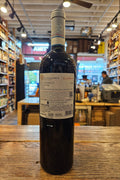 Wine bottle on a wooden surface with a blurred store interior in the background