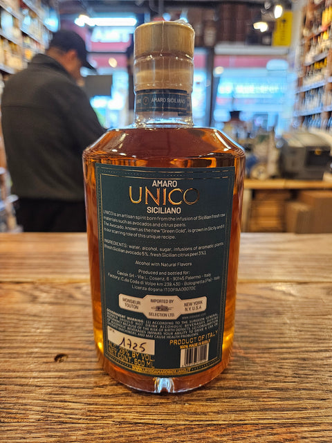 Bottle of Unico Amaro on a wooden surface with a blurred background