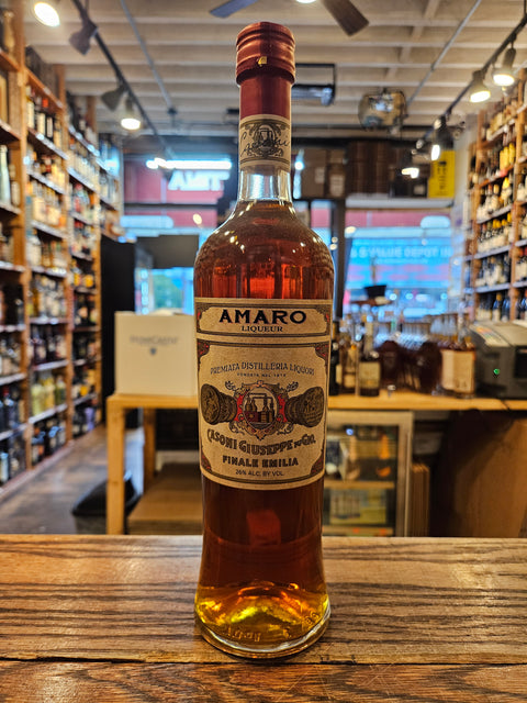 Bottle of Casoni Amaro on a wooden surface with a store interior in the background