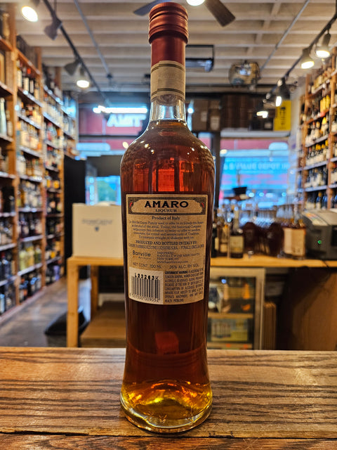 Bottle of Amaro on a wooden surface with a blurred bar background