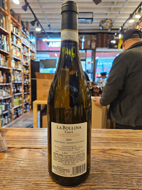 Bottle of La Bollina wine on a wooden surface with a store interior in the background