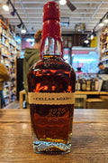 Bottle of 'Cellar Aged' whiskey on a wooden surface with a blurred store interior in the background.