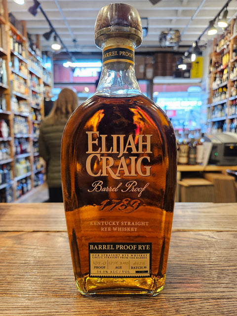 Bottle of Elijah Craig whiskey on a wooden surface with a store interior in the background