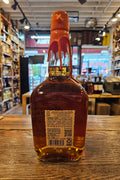 Bottle of amber liquid on a wooden surface with a blurred store interior in the background