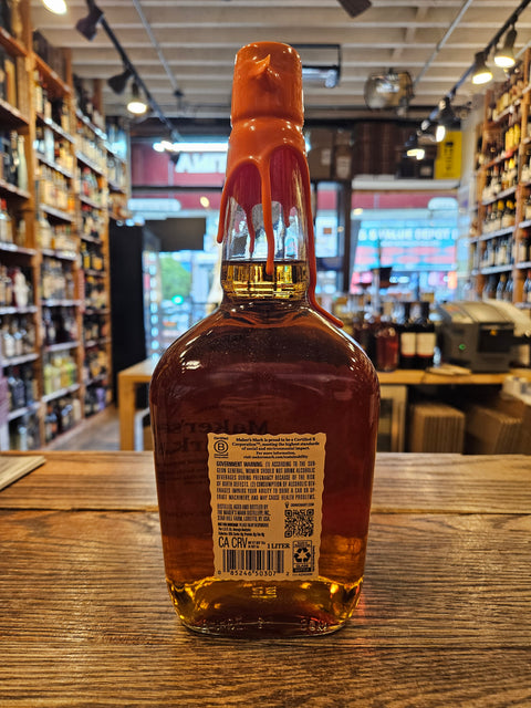 Bottle of amber liquid on a wooden surface with a blurred store interior in the background