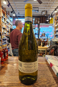 Wine bottle on a bar counter with a blurred background of a store interior.