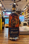 Bottle of American Whiskey on a wooden surface with a blurred bar background