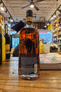 Bottle of whiskey on a wooden surface with a blurred bar background