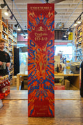 Bottle of Don Julio 1942 tequila on a wooden surface with a colorful label.