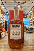 Bottle of Mount Gay Rum on a wooden surface with a store interior in the background