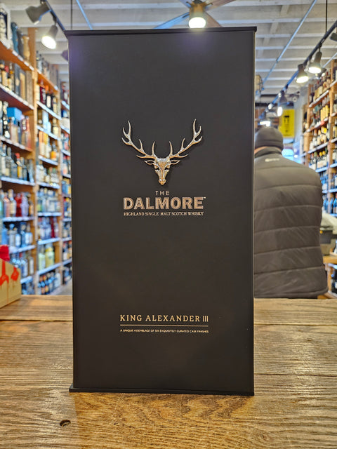 Dalmore King Alexander III whisky box on a wooden surface with a blurred indoor background