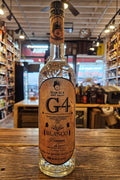 Bottle of G4 Blanco tequila on a wooden surface with a blurred bar background