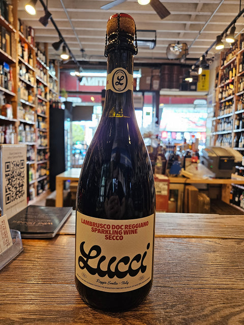 Bottle of Lucci sparkling wine on a wooden surface with a store interior in the background