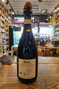 Bottle of wine on a wooden surface with a store interior in the background