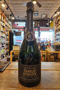 Bottle of Charles Heidsieck champagne on a wooden surface with a store interior in the background