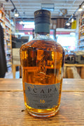 Scapa whisky bottle on a wooden surface with a blurred store interior in the background