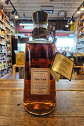 Bottle of whiskey on a wooden surface with a blurred indoor background